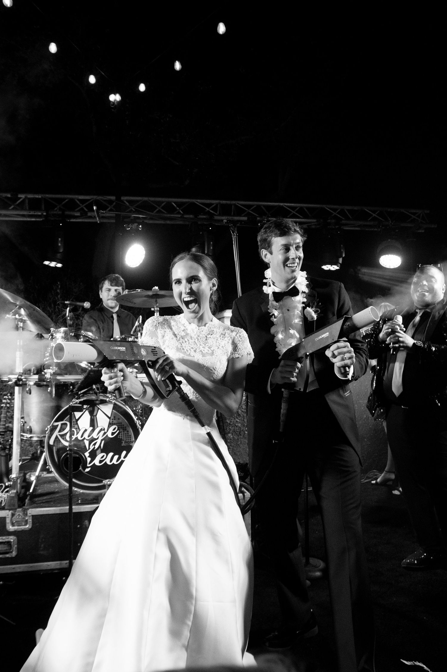 Black and white wedding reception dance party with dramatic lighting.