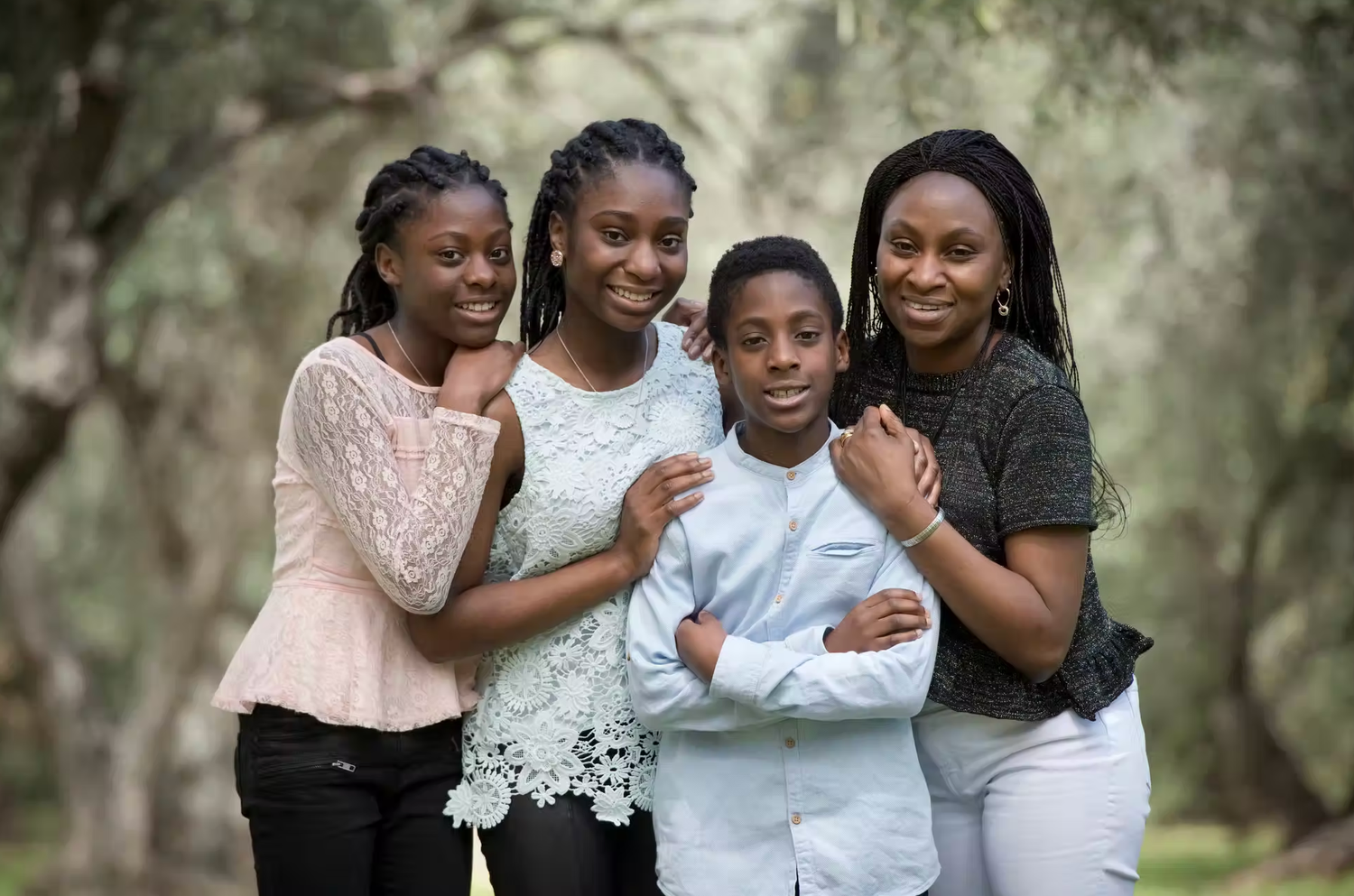 Group of four people sharing a joyful embrace outdoors.