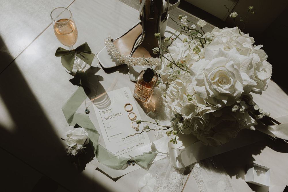 Elegant white floral arrangements and place settings on a wedding reception table.