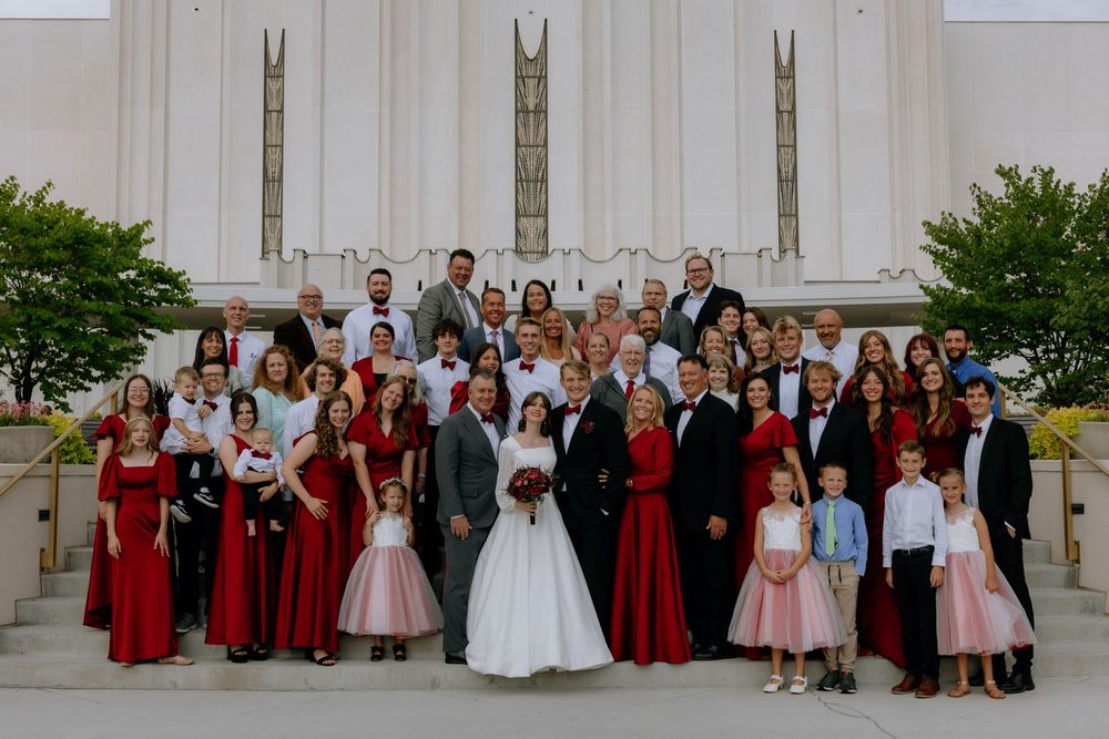 A wedding party poses together in a series of outdoor photos wearing red and white formal attire.