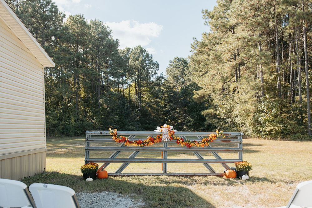 Rustic outdoor wedding venue decorated with fall pumpkins and harvest decor.