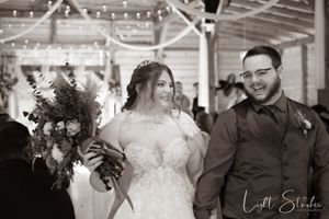 Wedding celebration with string lights and dancing guests in a rustic indoor venue at a farm wedding in North Carolina.