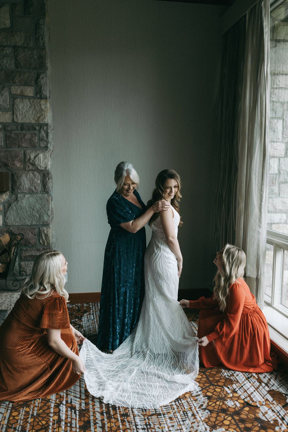 Series of intimate moments showing women in rust-colored dresses and white gown by a window with stone walls.