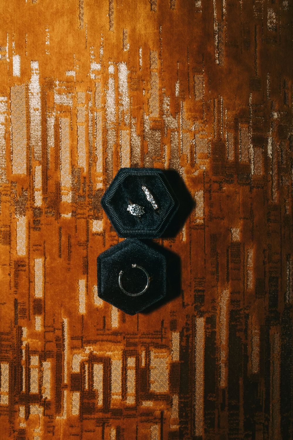 Vintage-style wooden wall with orange and brown tones featuring decorative black octagonal boxes mounted on it.