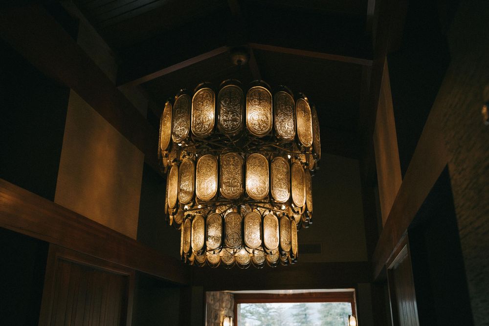 Rustic wedding venue interior with vintage-style pendant lighting and wooden beams.