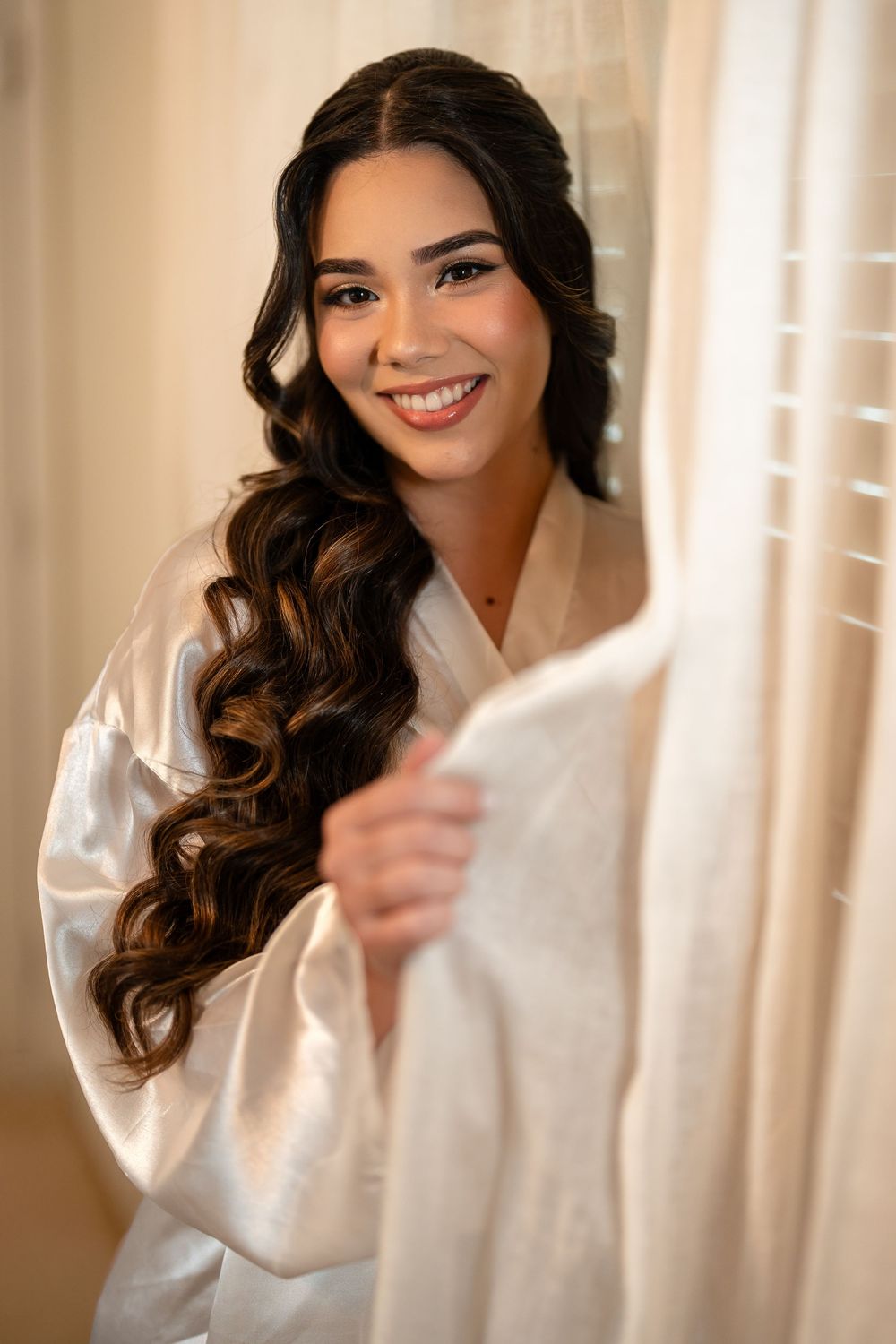 Getting ready scene with white silk robe in soft window light.