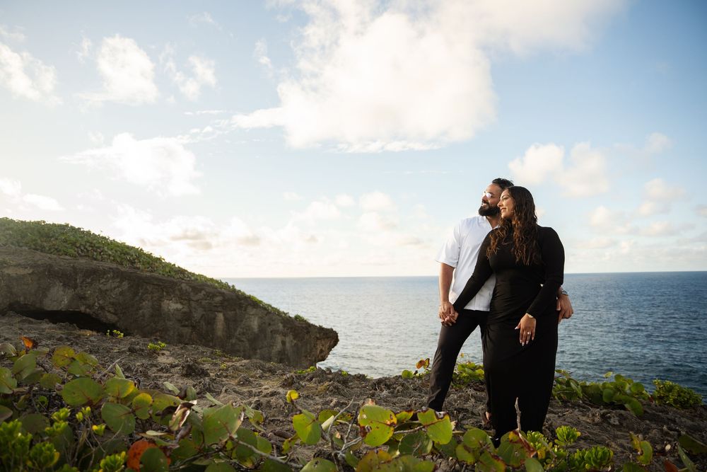 Romantic couple shares intimate moments along scenic coastal cliffs overlooking the ocean at sunset.