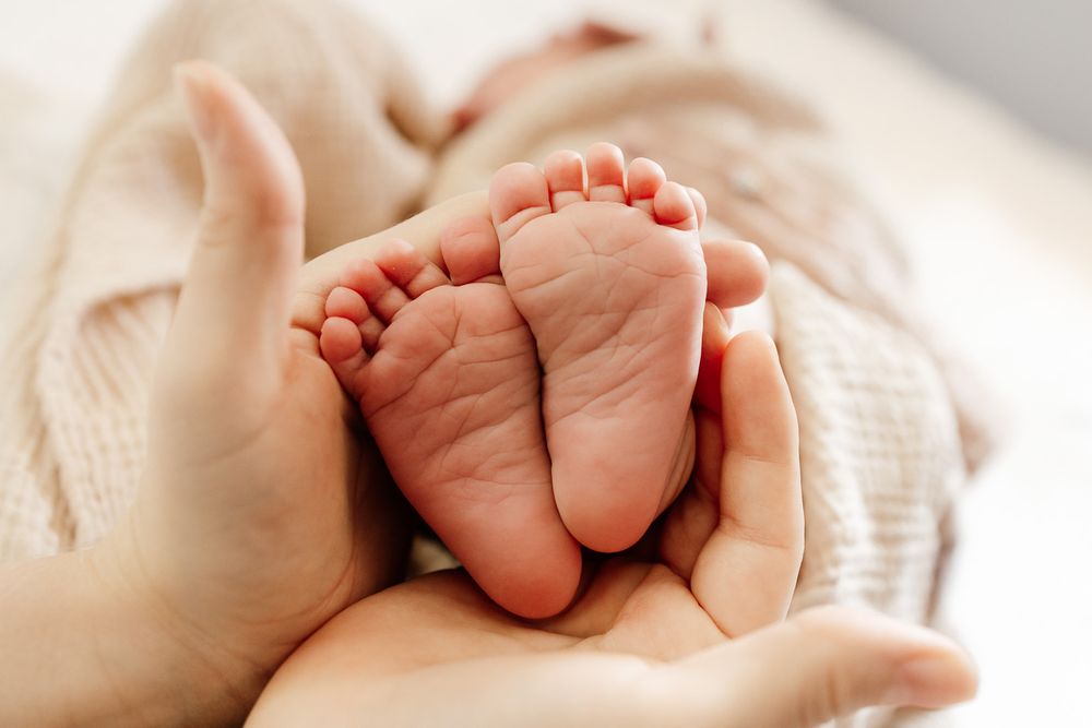 Close-up of tiny baby feet cradled in mom's hands - Bay Area newborn details