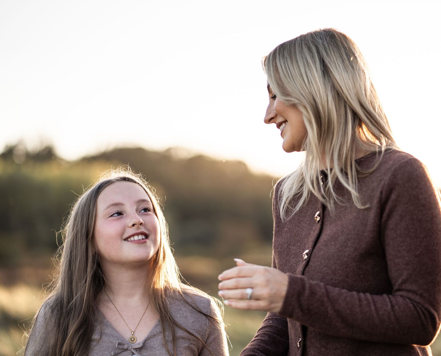 A sequence of five images showing a mother and daughter having a conversation outdoors at sunset.