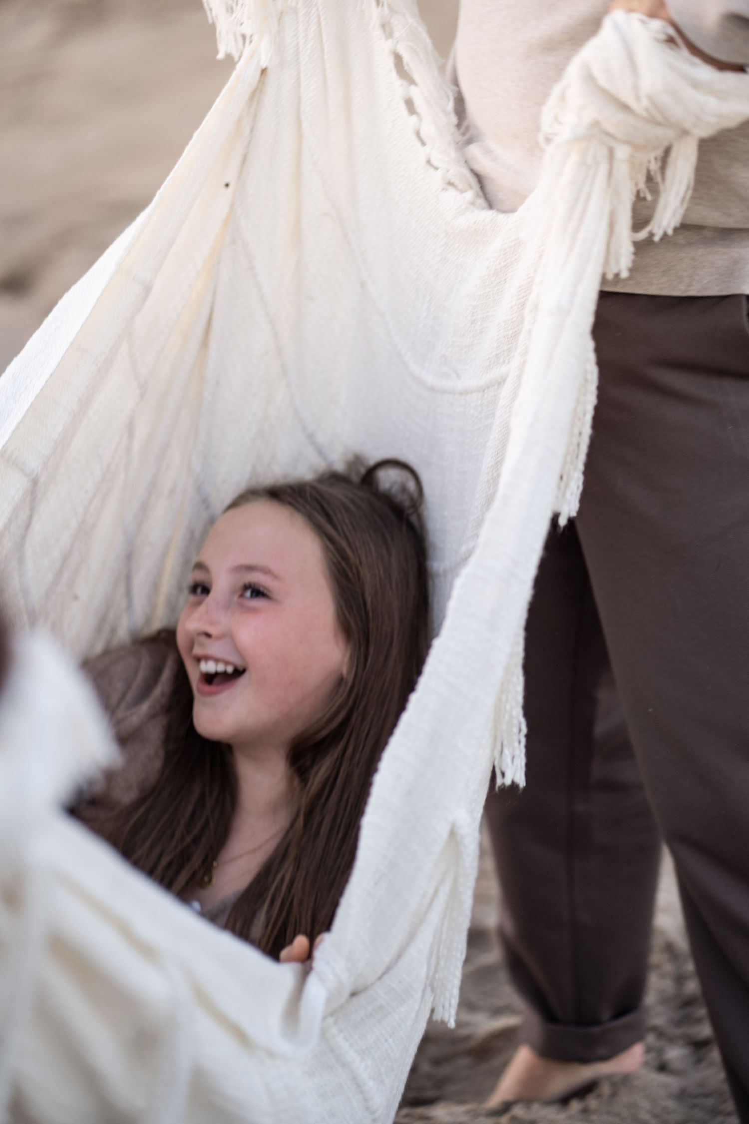 Series of candid shots showing playful laughter while wrapped in flowing white fabric.
