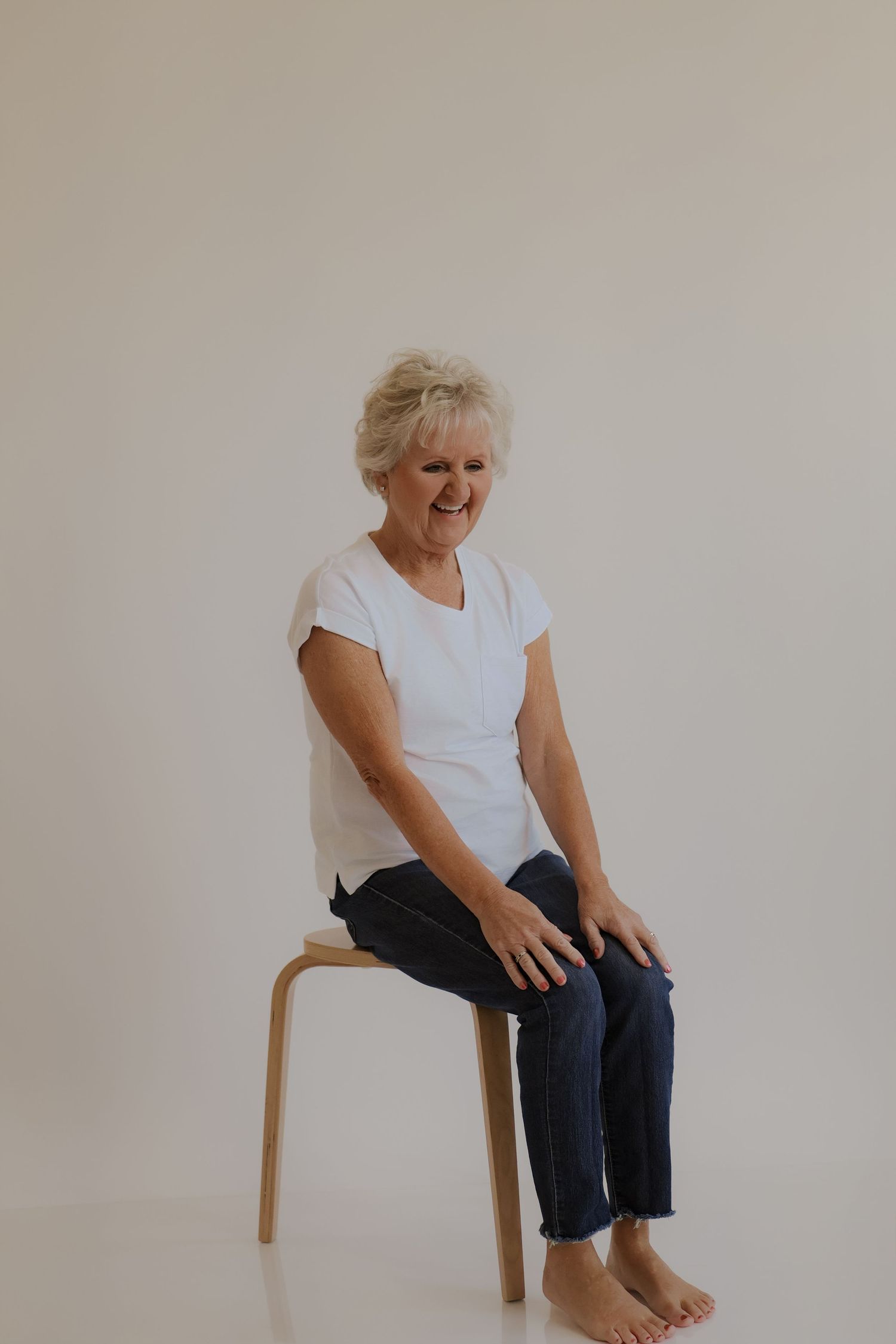 Studio portrait session showing relaxed poses against neutral wall.