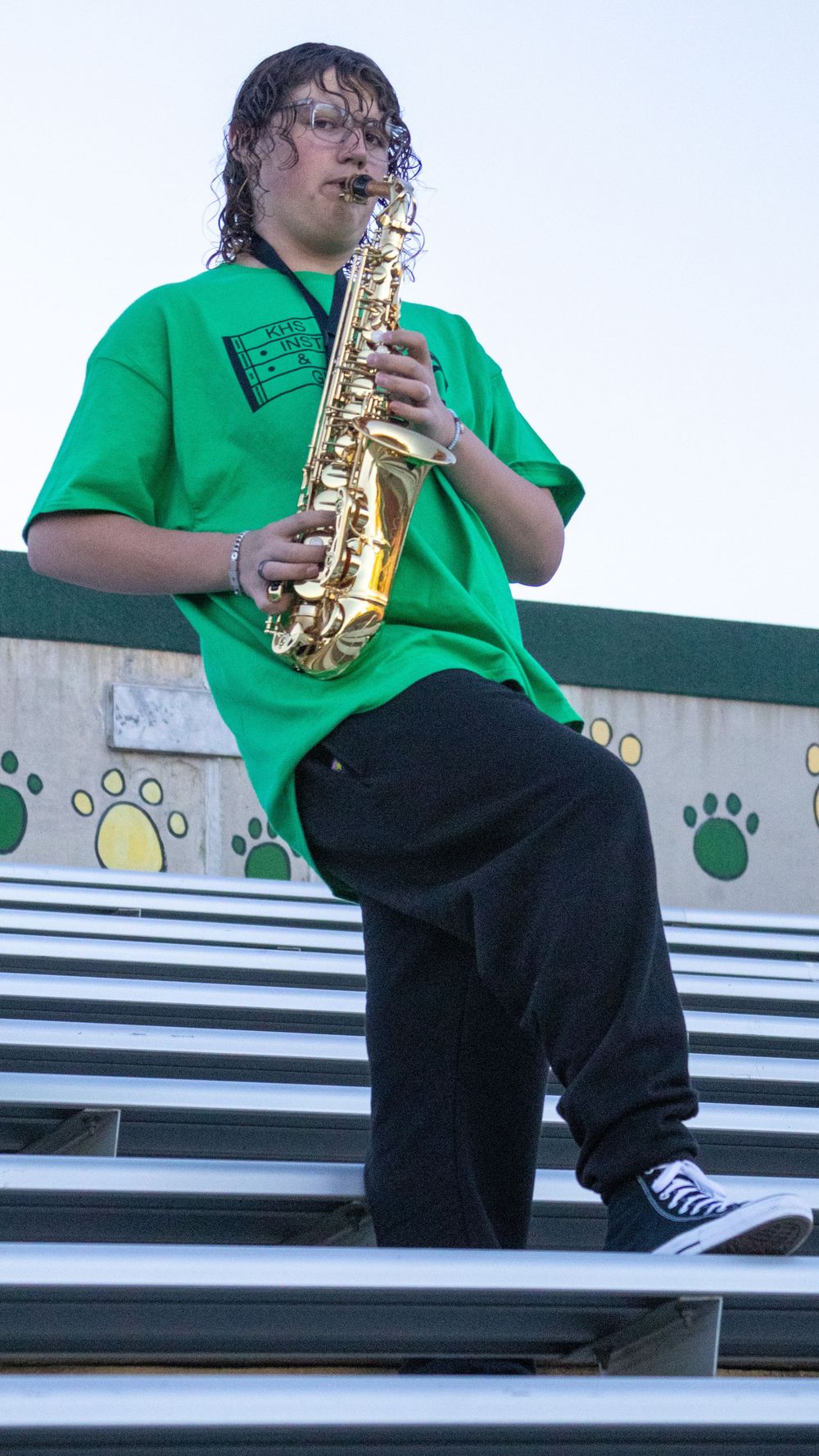 Teen boy playing saxophone during a candid senior photography session in Utah
