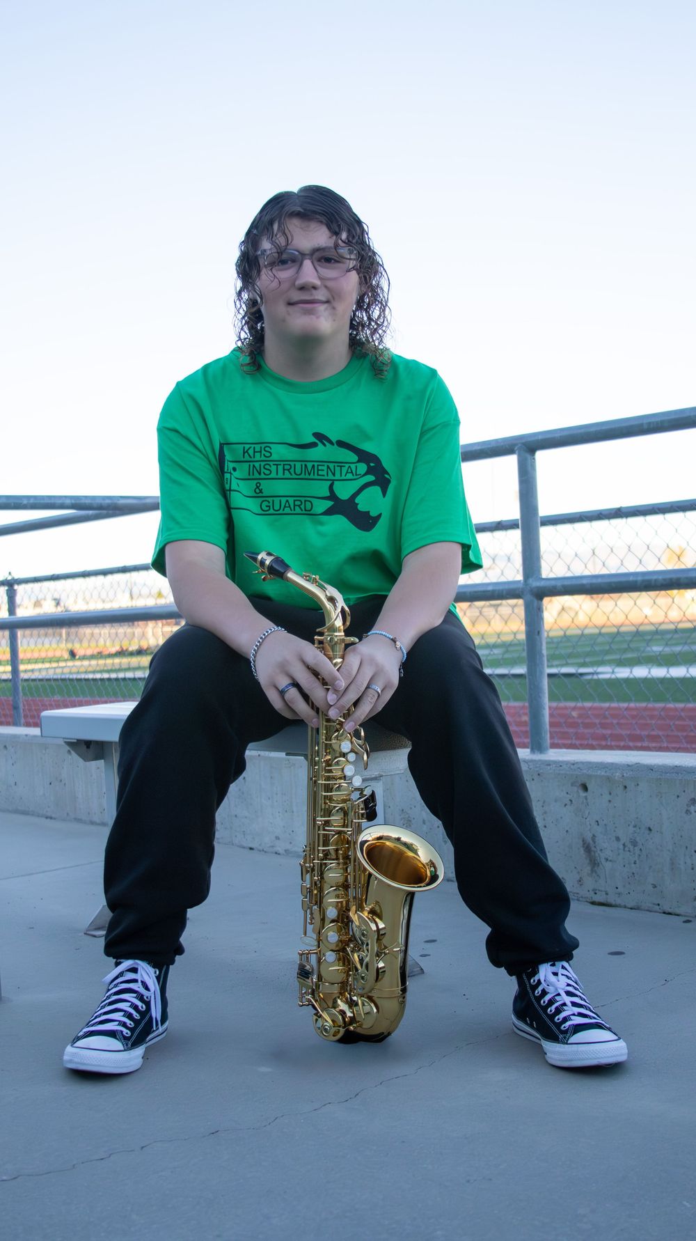 Teen boy sitting with saxophone during a relaxed senior portrait session