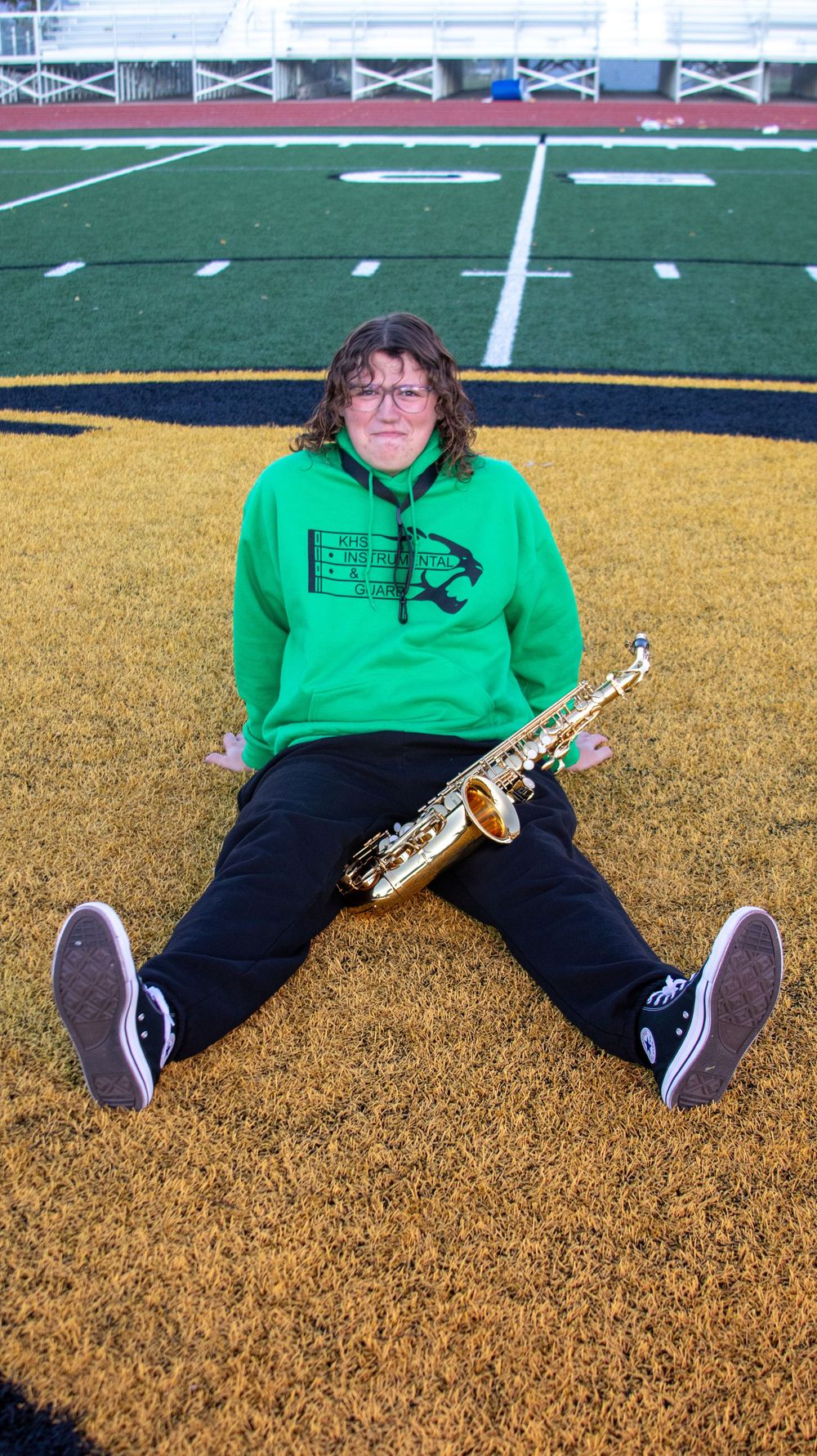 Teen boy posing with a saxophone during an outdoor senior portrait session