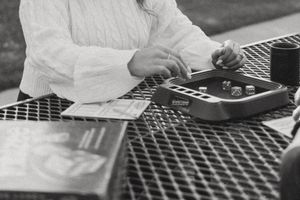 A couple sits together at a picnic table in a romantic outdoor setting at sunset.
