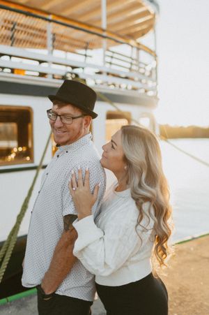 A couple shares a joyful moment together during sunset by the water.