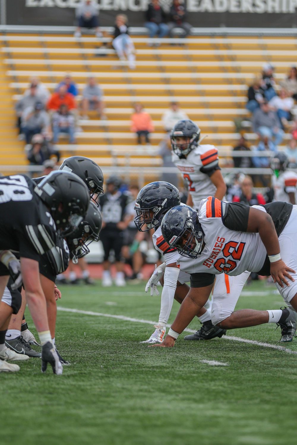 Football players from opposing teams line up in formation at the line of scrimmage during a game.