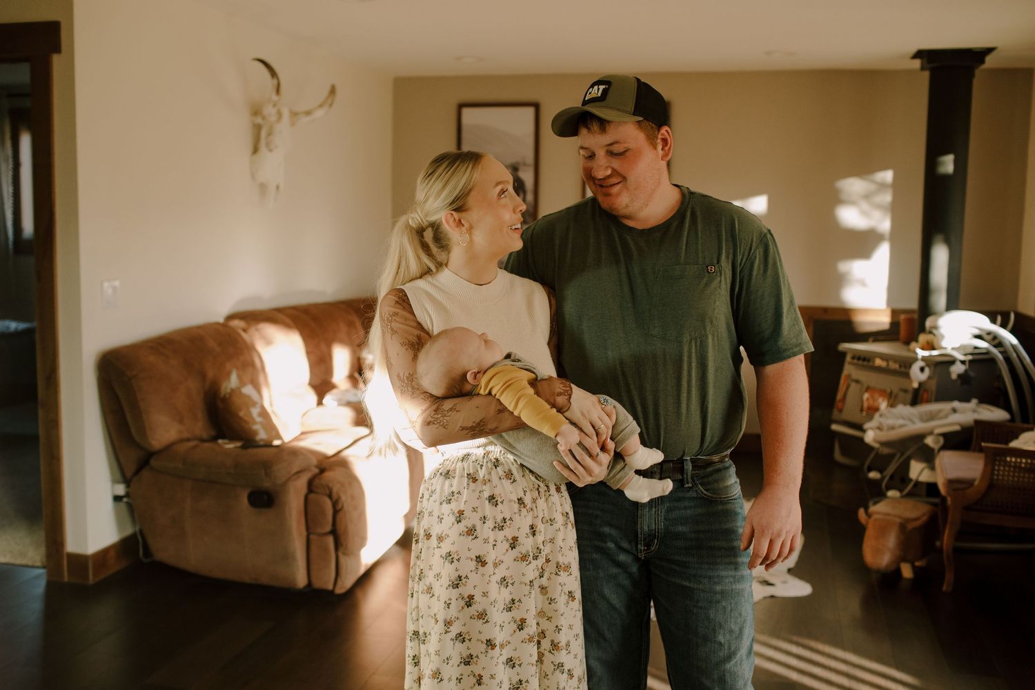 A sunlit indoor family moment with a baby in a cozy living room setting.