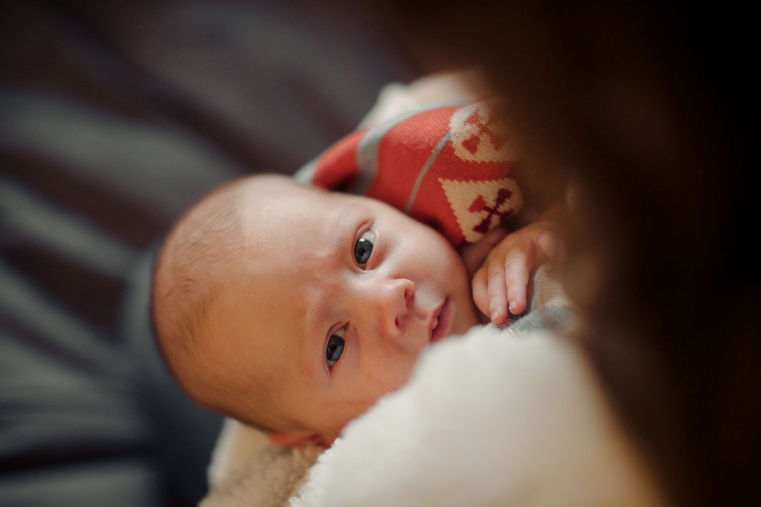 Close-up shots of a baby lying down in soft lighting.