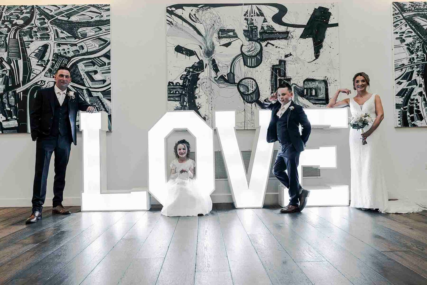 A group of people perform dance moves in a modern studio space with black and white artwork on the walls.