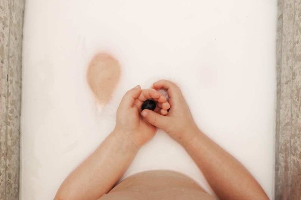 Overhead view of tiny hands during a toddler milk bath session | Broomfield Family Photographer