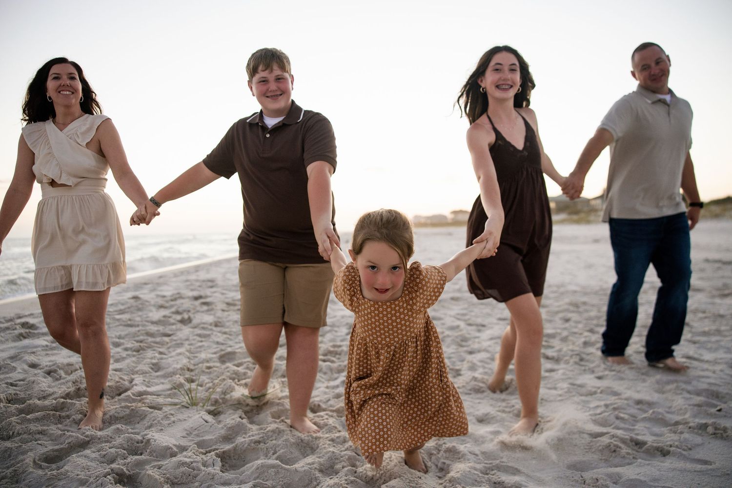 family portrait in gulf breeze, Florida family running down the beach