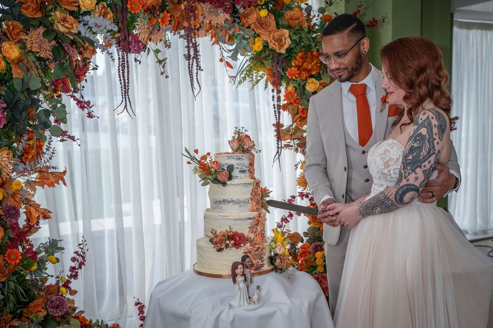 Elegant floral arch with orange and white flowers creates a romantic wedding ceremony backdrop.
