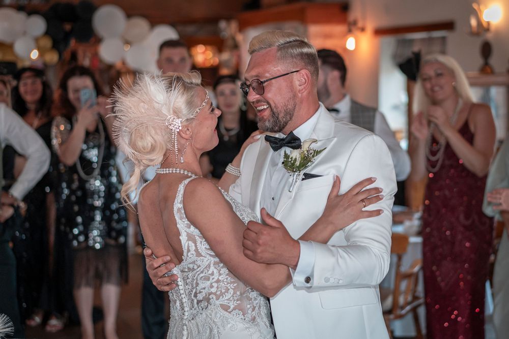 Couples dancing together at an elegant wedding reception with romantic lighting.