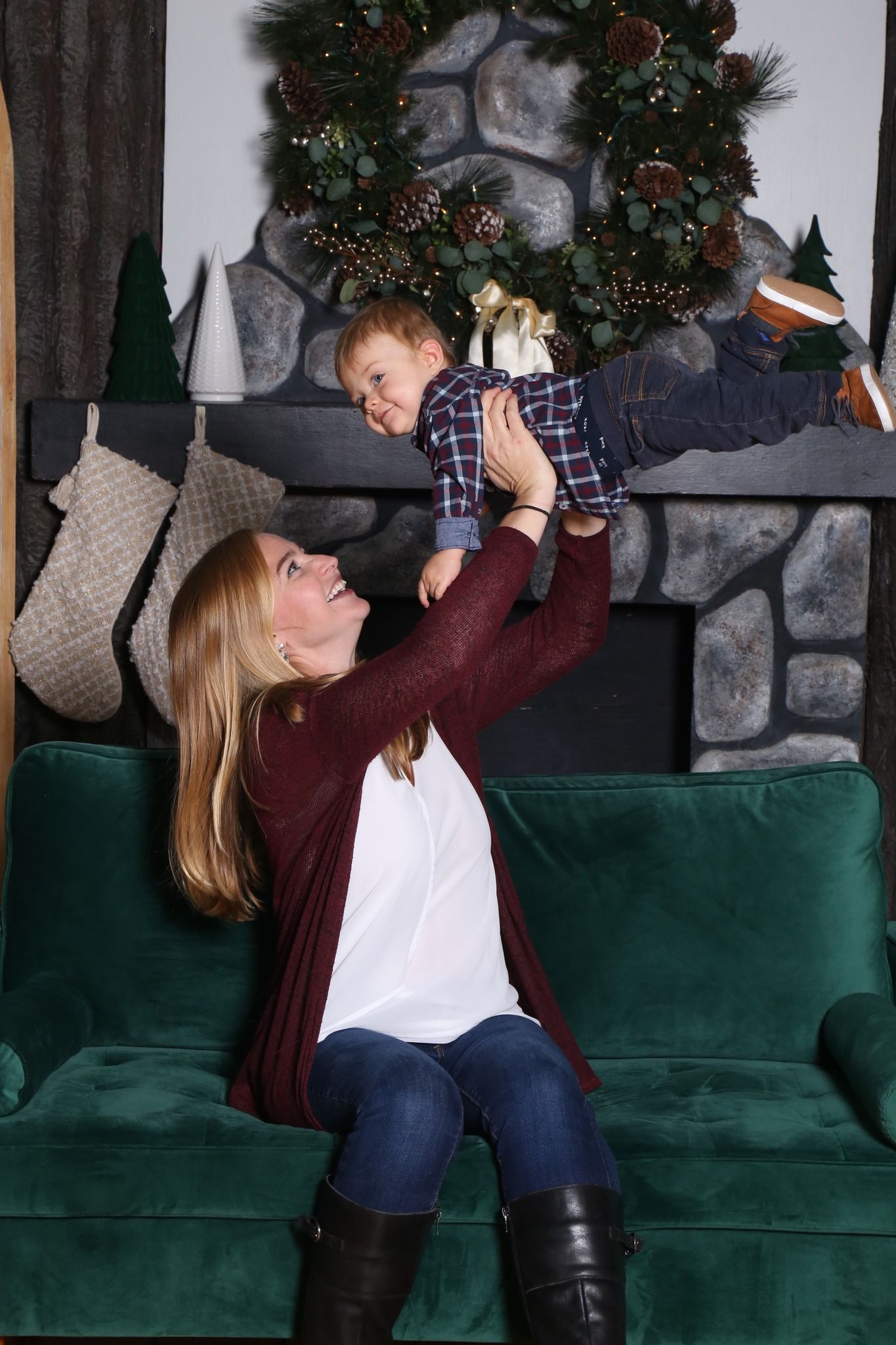 Woman and toddler in matching red plaid flannel shirts sitting on a bench outdoors, smiling together.
