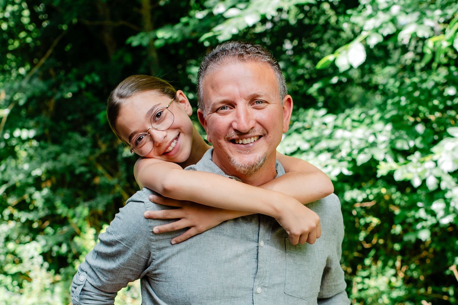 Père et fille souriant dans la forêt