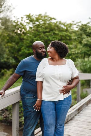 A series of candid photos showing a couple walking together on a wooden boardwalk surrounded by greenery.