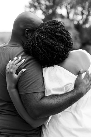 Close-up black and white photo of an intimate embrace during an outdoor photoshoot.
