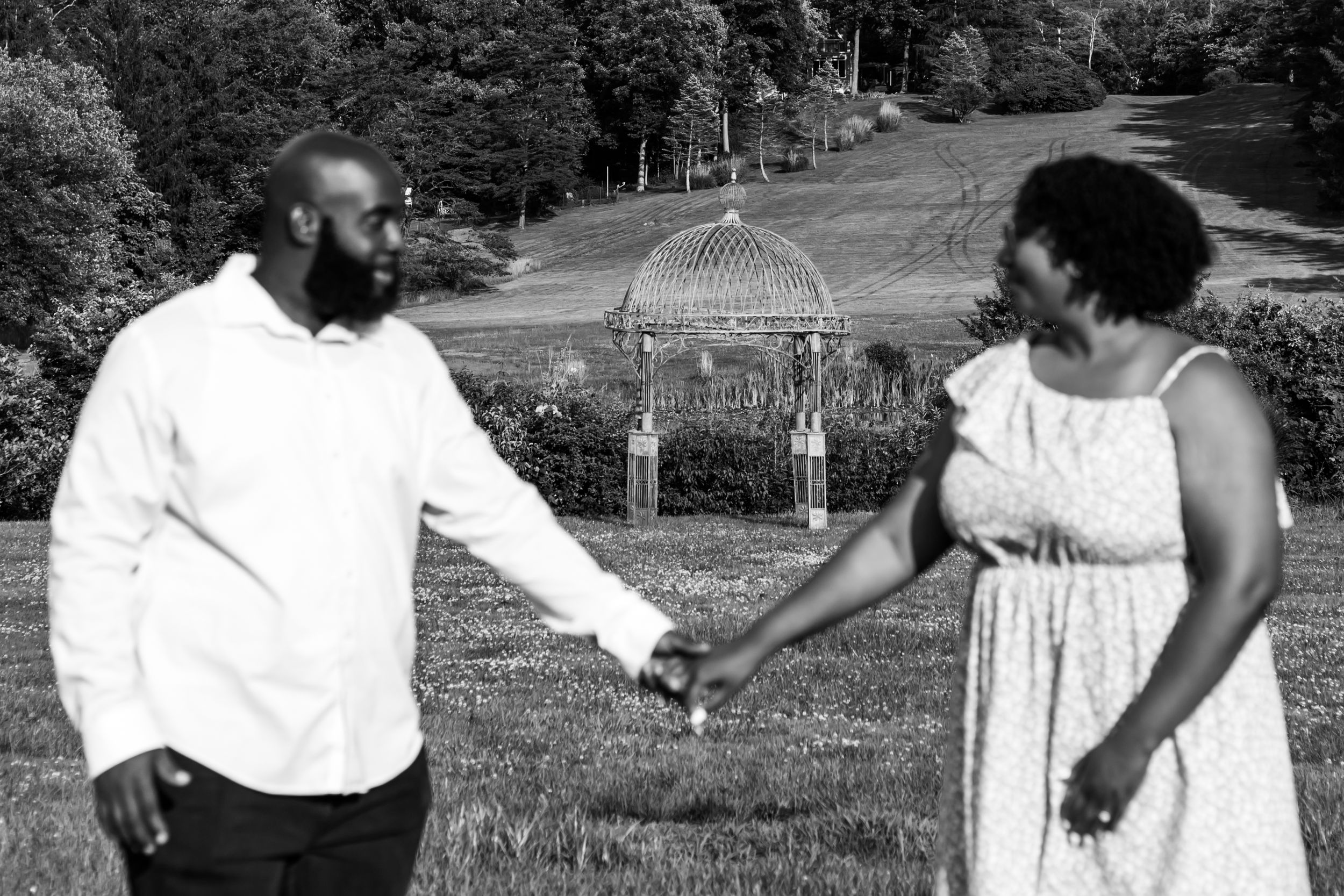 Black and white photo sequence showing two people dancing together in a park setting.