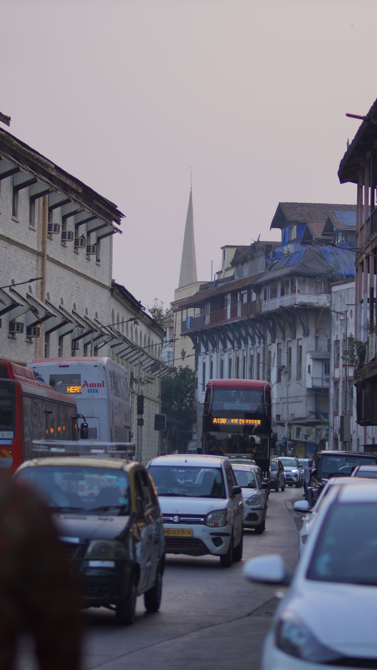 A narrow city street viewed during the blue hour, showcasing the weary architecture and silent rhythm of the town.