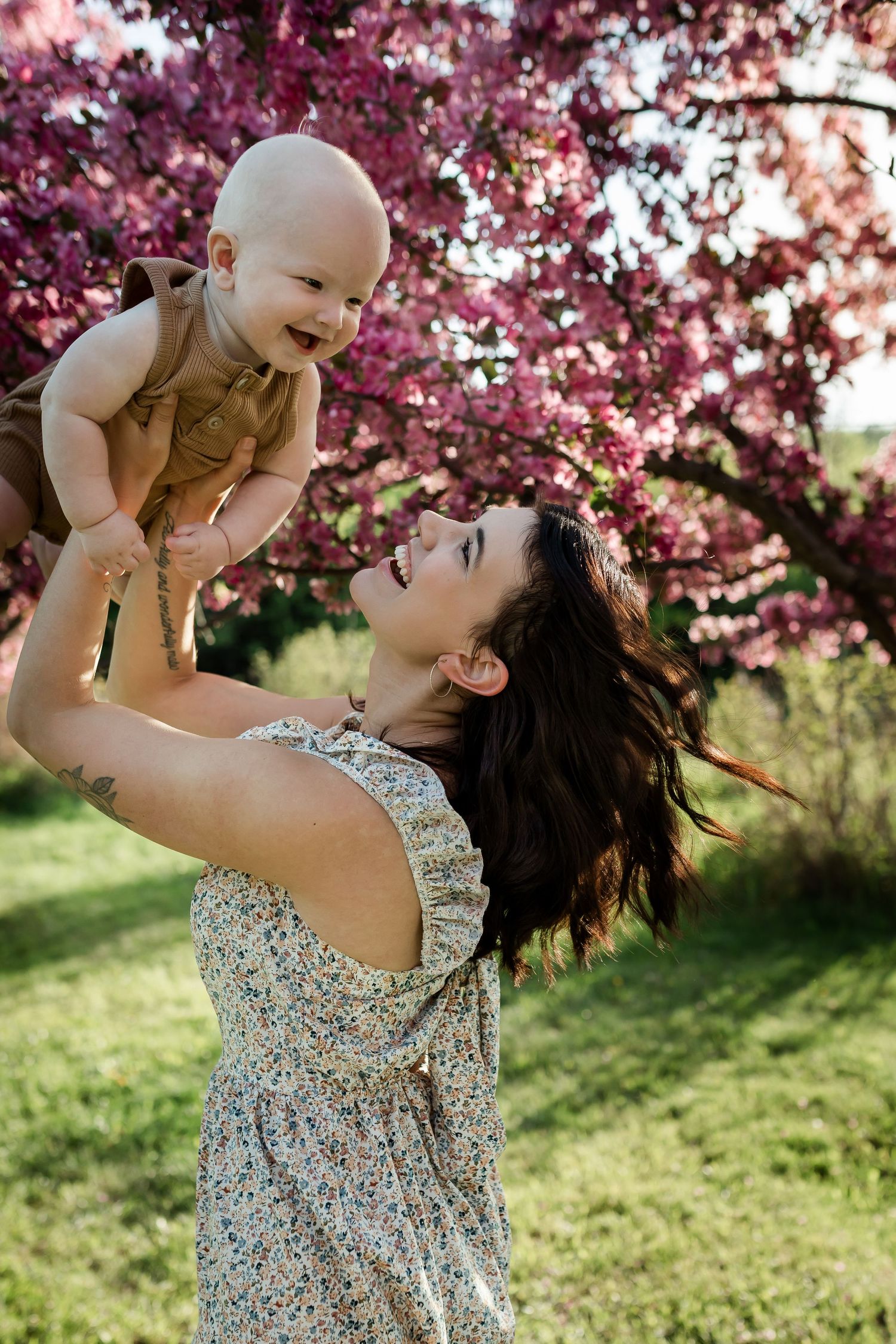 Beautiful motherhood moment in cherry blossoms at spring time by Calgary family photographer, Love & Sunshine Photography.