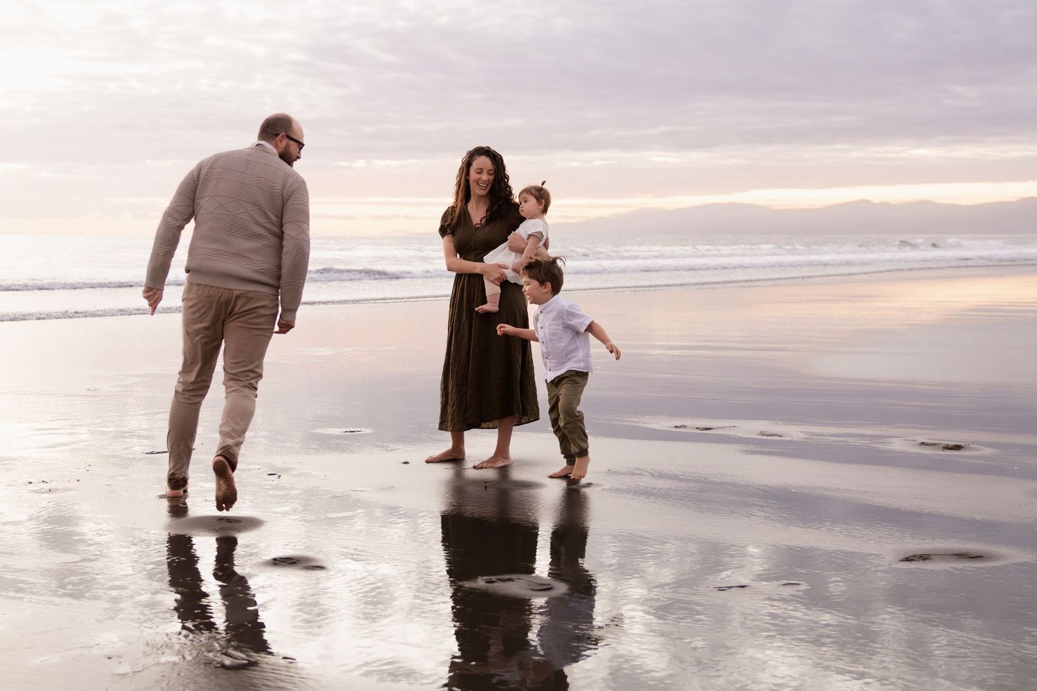 sunrise family session, son chasing dad while mum holds daughter