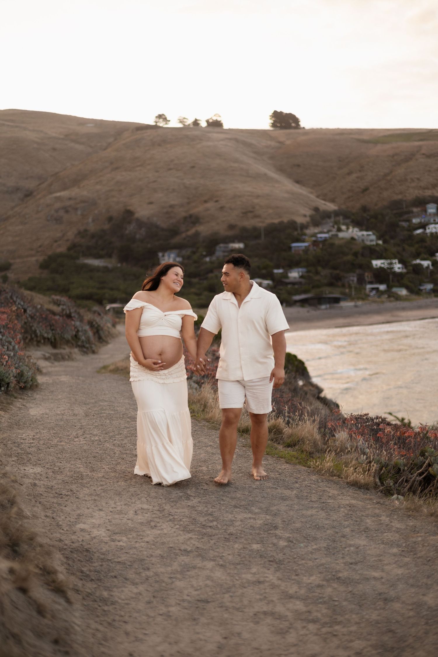 Maternity session at Taylors Mistake, couple walking up the hill