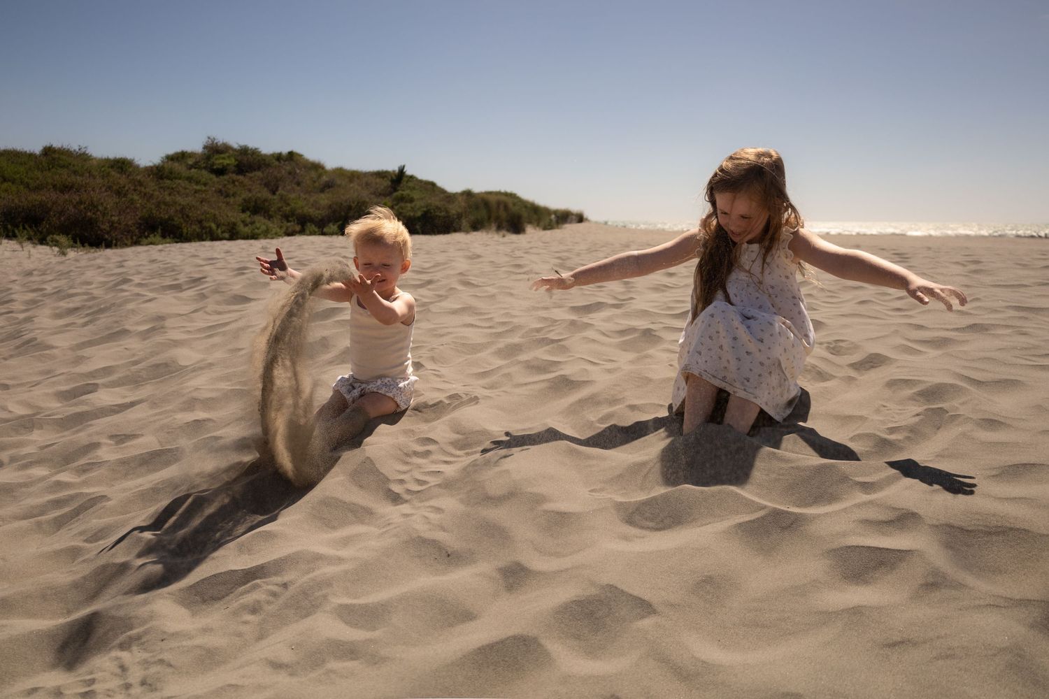 kids playing in the sand at the beach during family session