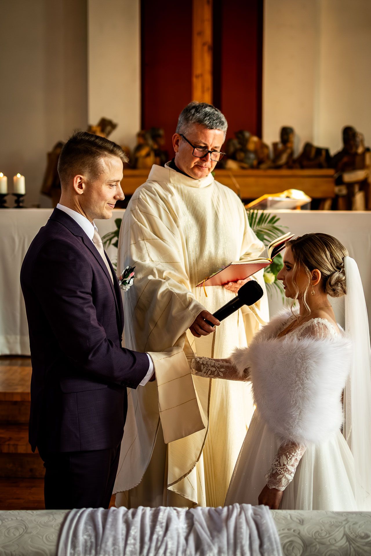 Wedding ceremony in progress with priest performing traditional rituals.