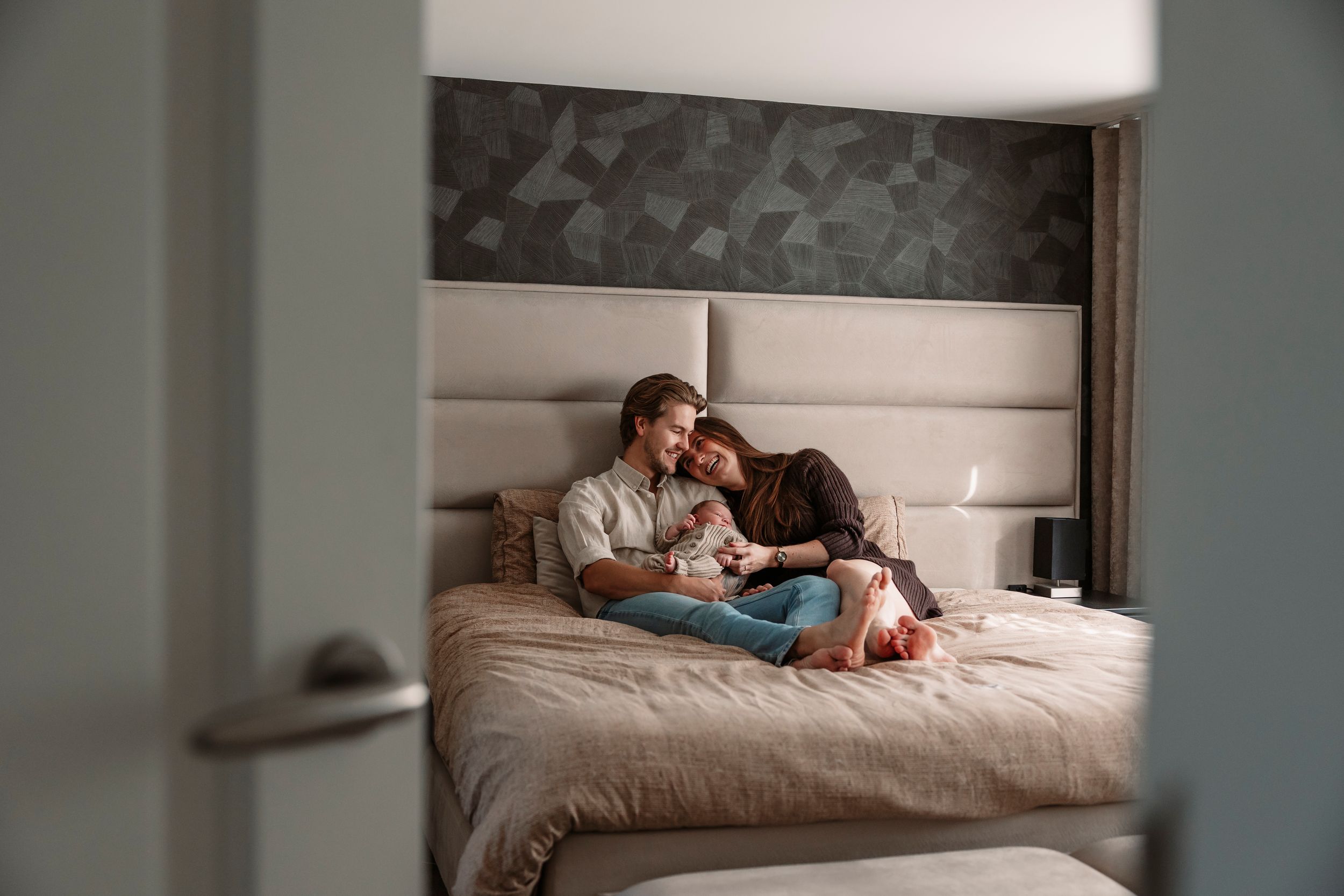 Cozy bedroom scene with soft lighting and people reading together on bed.