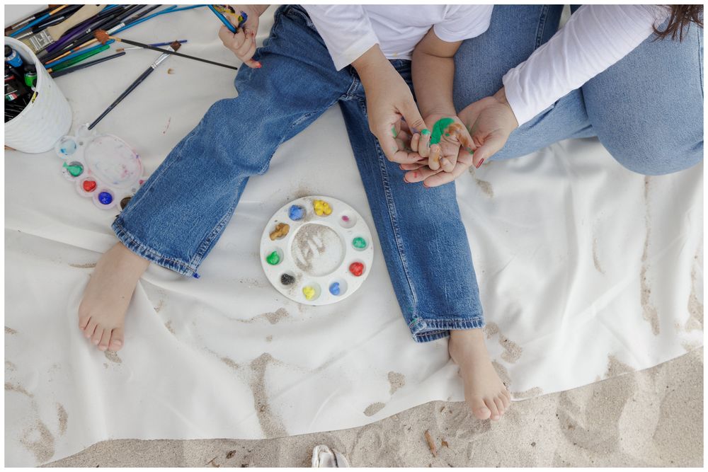 People playing the classic Twister party game on a white mat with colorful dots.