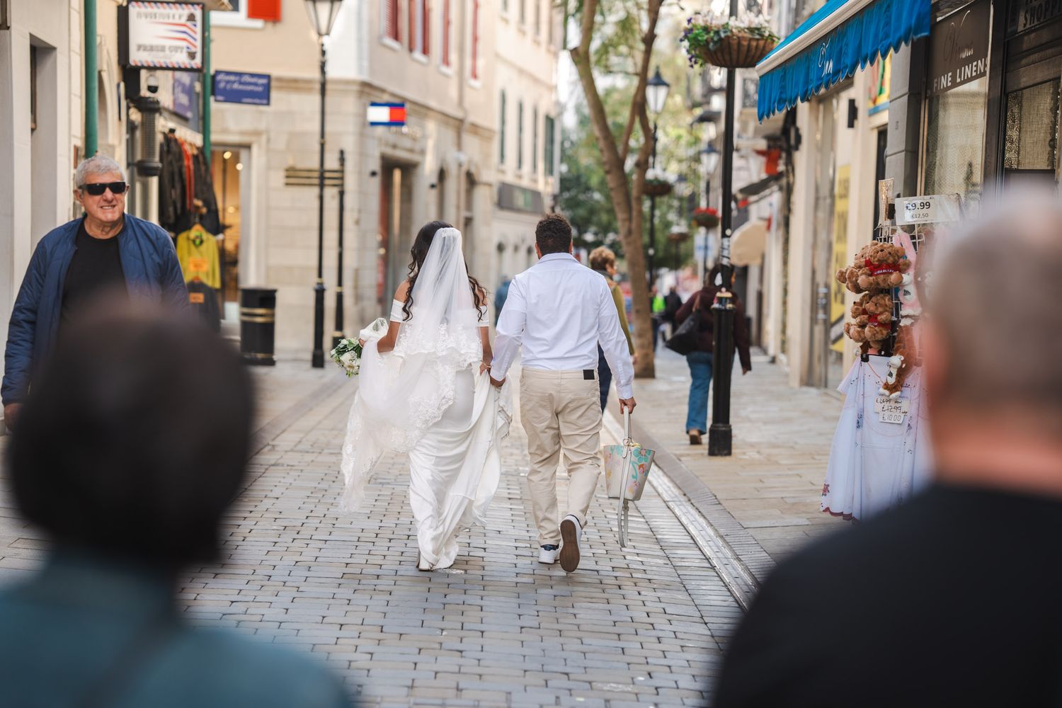 Wedding Couple walk through Main Street in Gibraltar no their wedding day