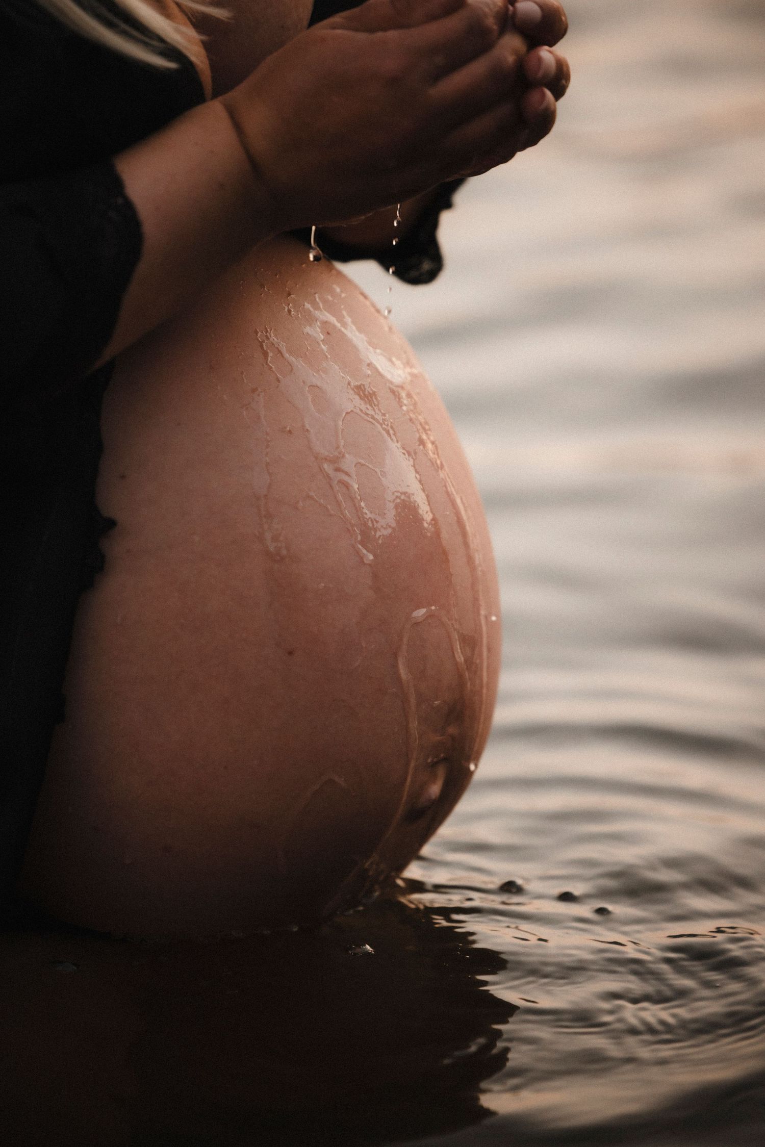 A series of artistic close-up shots showing a pregnant belly submerged in rippling water during a maternity photoshoot.