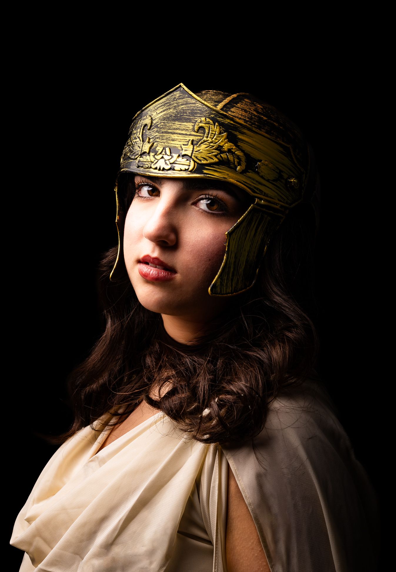 Athena, Goddess of Wisdom, Strategic Warfare, Handicraft and Reason, black backdrop with a girl in a golden helmet looking forward (1)