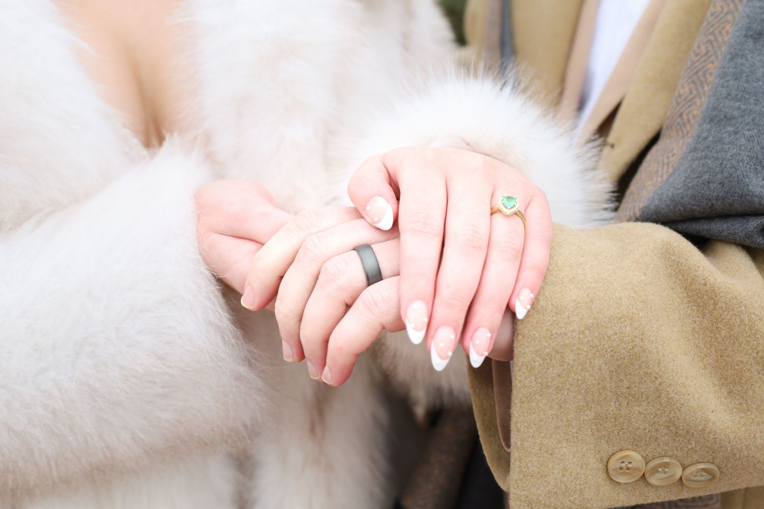 Close-up details of hands against light colored fabric texture.