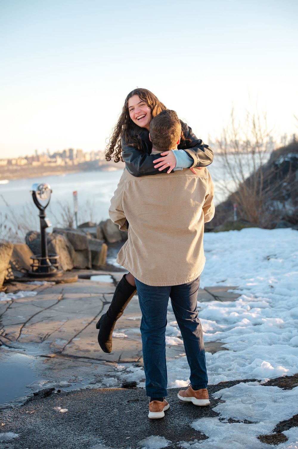 A romantic winter photoshoot sequence showing a couple dancing and embracing on a snowy shoreline at sunset.