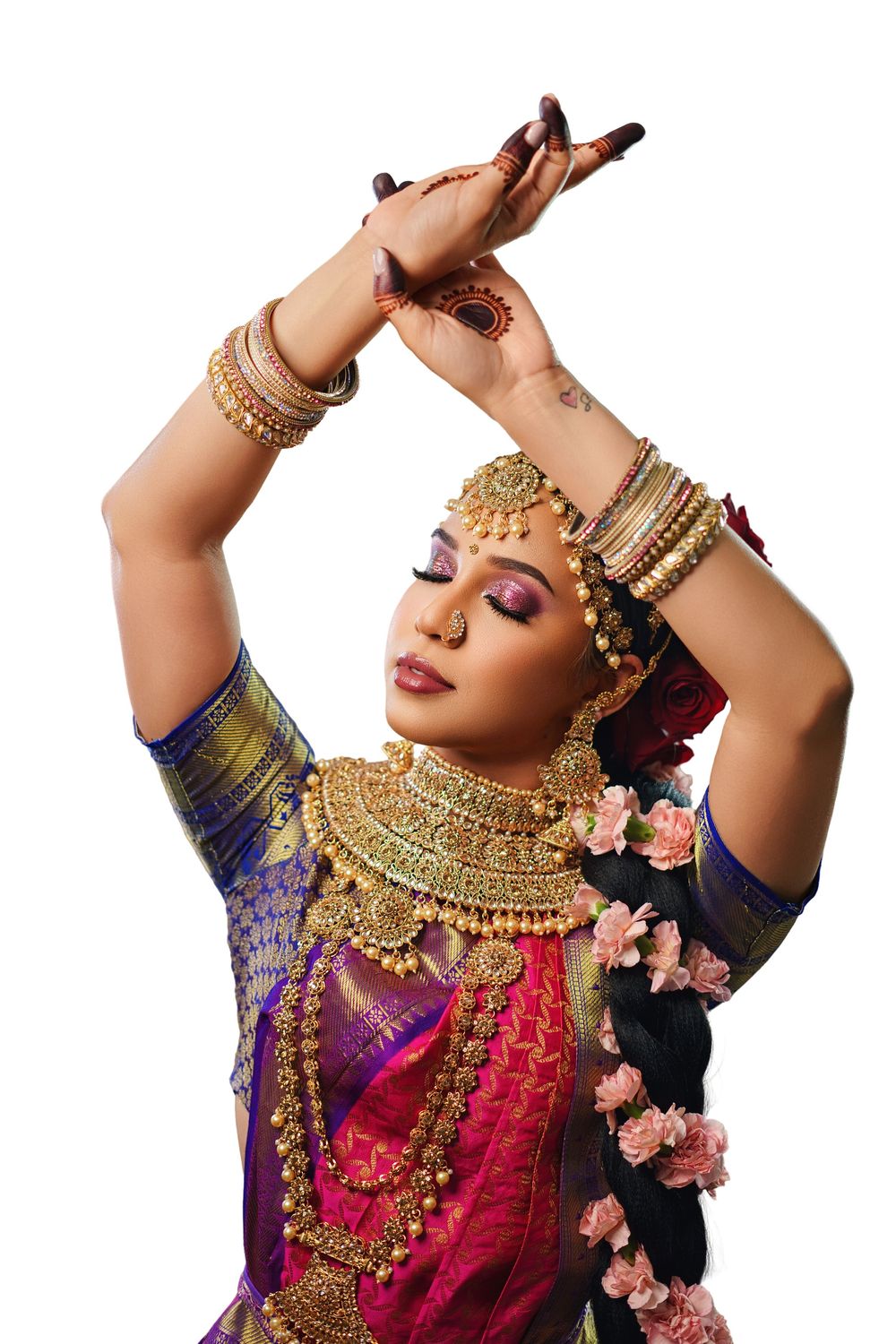 Classical Indian dancer wearing traditional gold jewelry and colorful silk costume performs graceful hand movements.