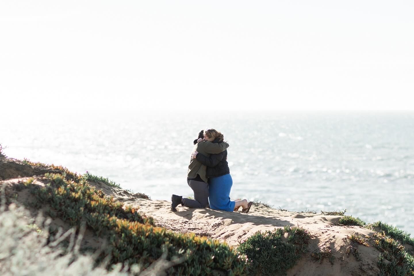 A heartfelt proposal on a cliff edge with panoramic views of the ocean and coastline.