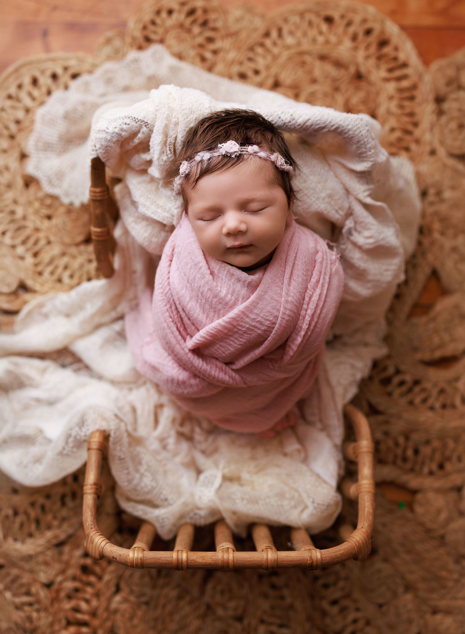 Photograph of a newborn baby girl swaddled in pink