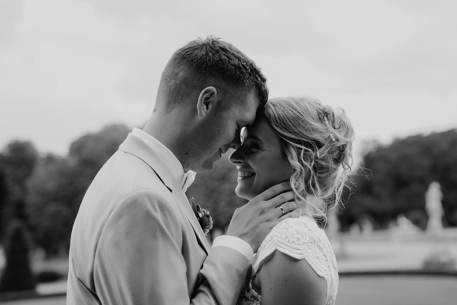 Black and white wedding photos showing romantic kisses between couples in outdoor settings.